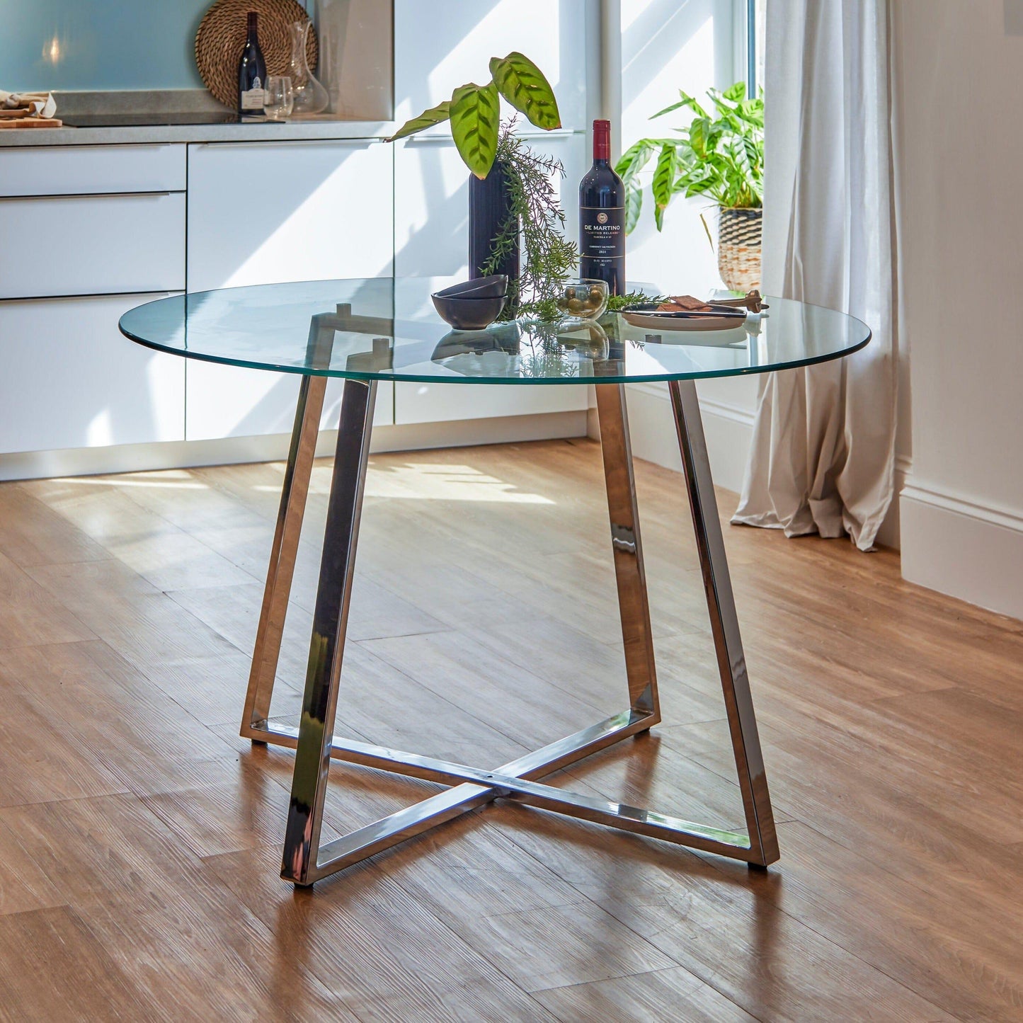 Clara glass round dining table - with chrome frame - Laura James