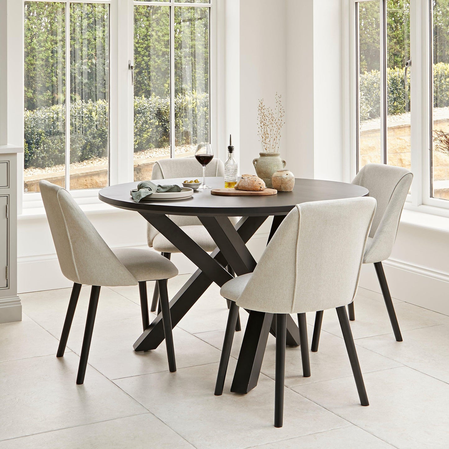 Levi Black Round Dining Table Set - 4 Seater - Freya Sand Dining Chairs - Black Oak legs